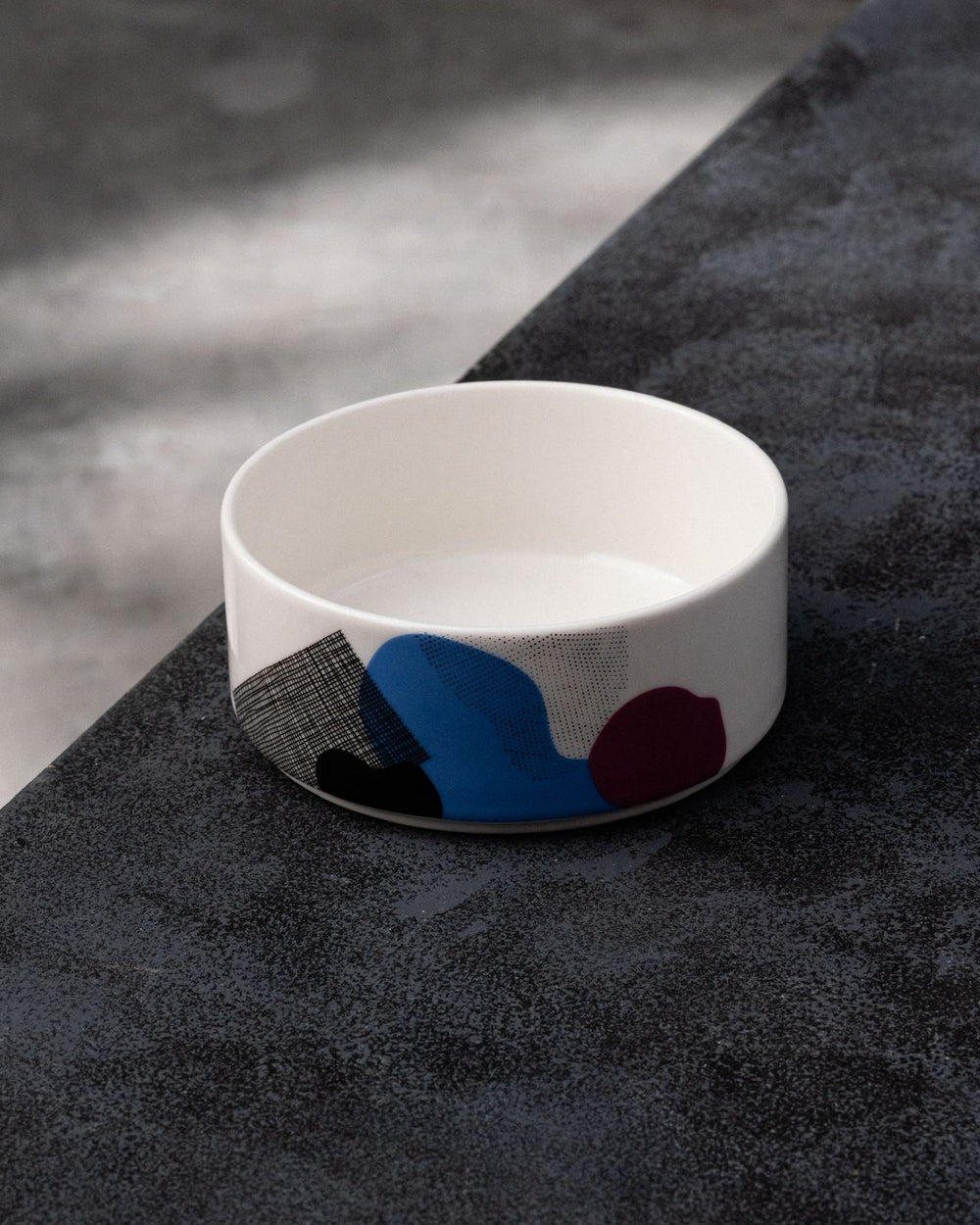 White bowl with abstract blue, red, and black design