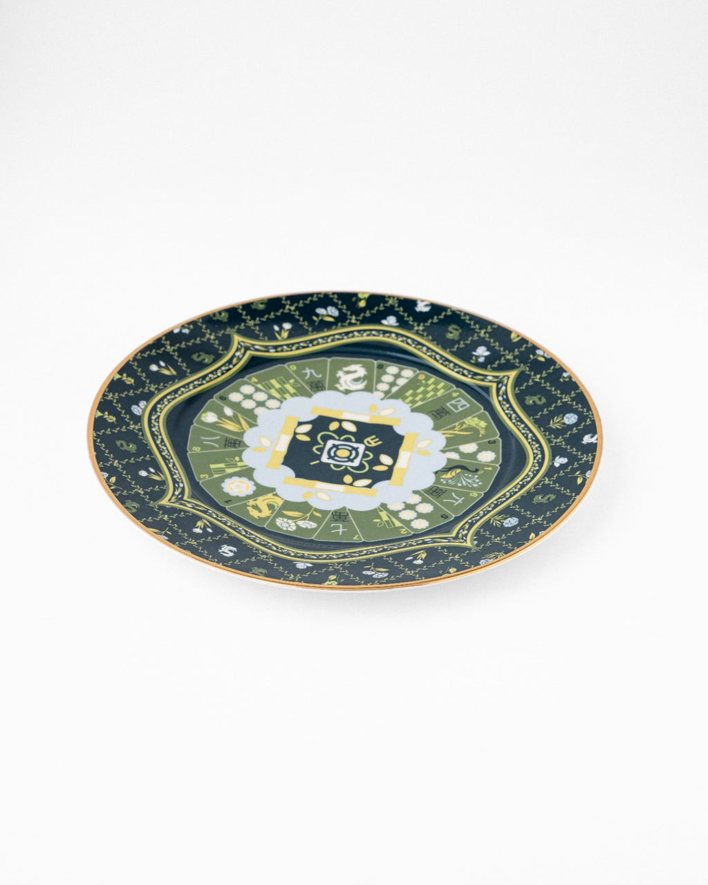Navy ceramic serving plate with gold trim and ornate green floral central medallion, photographed at angle on white background