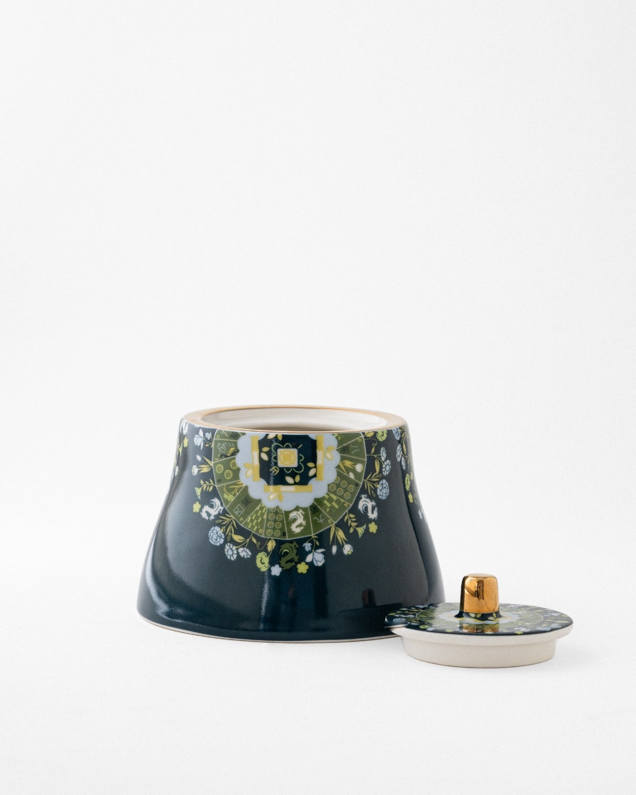 Navy blue sugar bowl with matching lid beside it, showing cream-colored inside and green flower pattern
