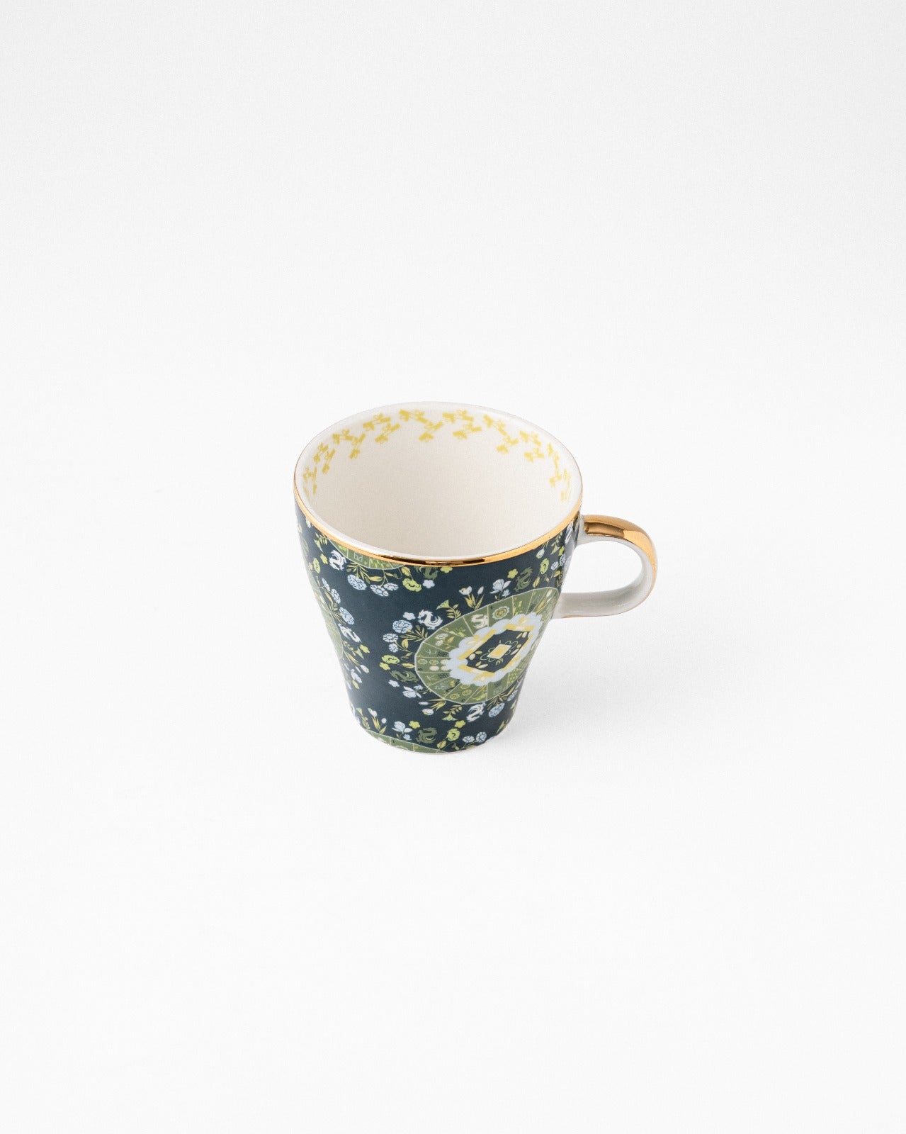 Navy teacup with beige handle and green floral pattern, cream interior on white background