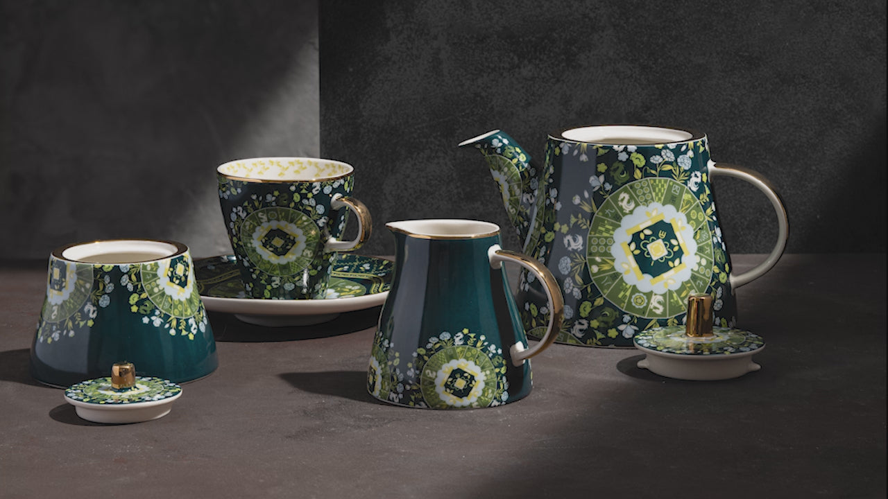 Video demonstrating complete teal ceramic tea service with white and green floral details, featuring cups, saucers, teapots, and serving vessels